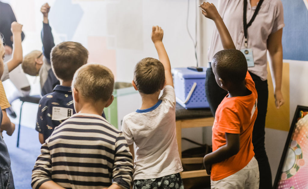 Students raising hand in classroom