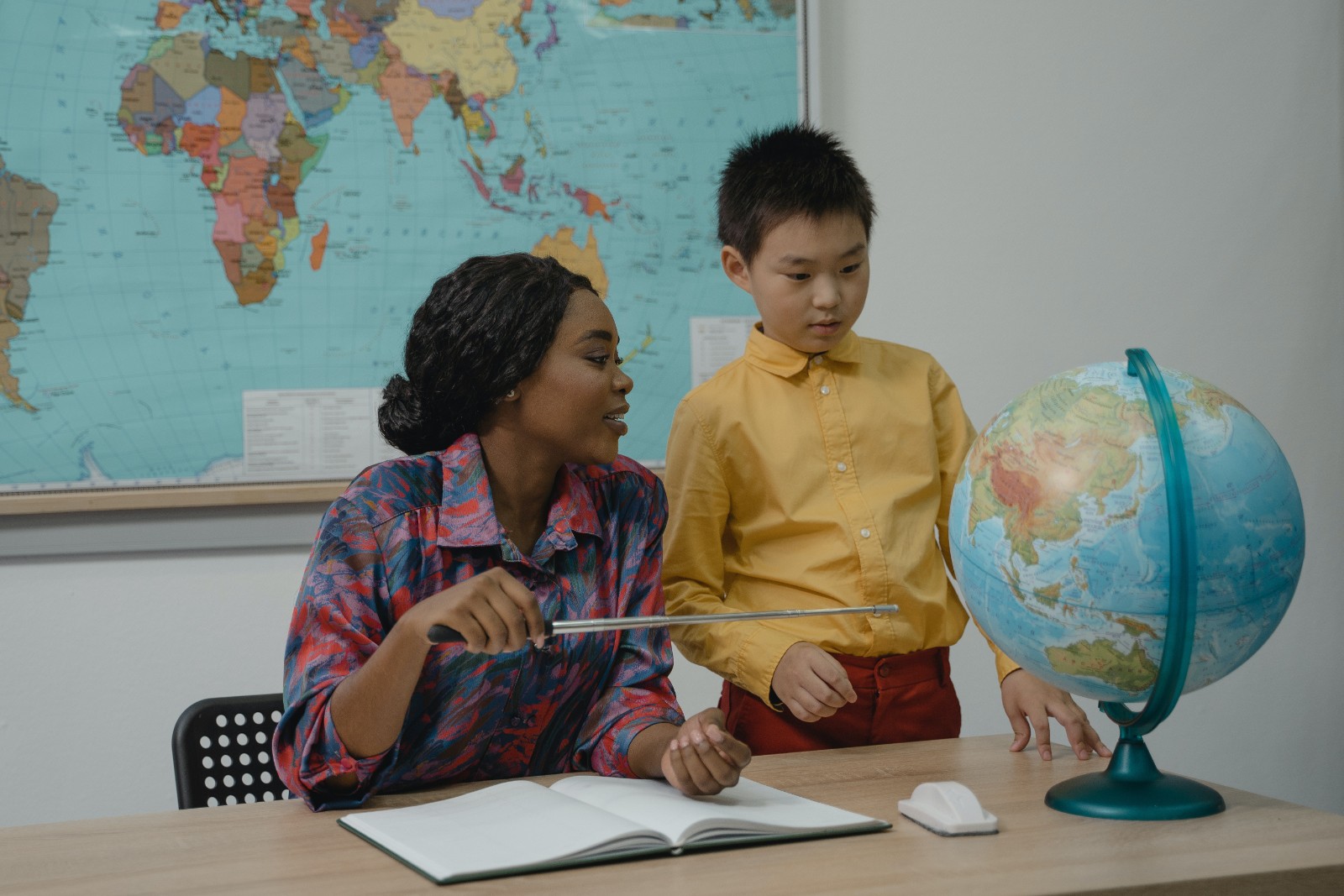 teacher and student looking at a globe