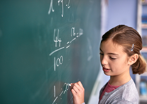 girl writing on a chalk board