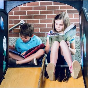 children reading on a slide